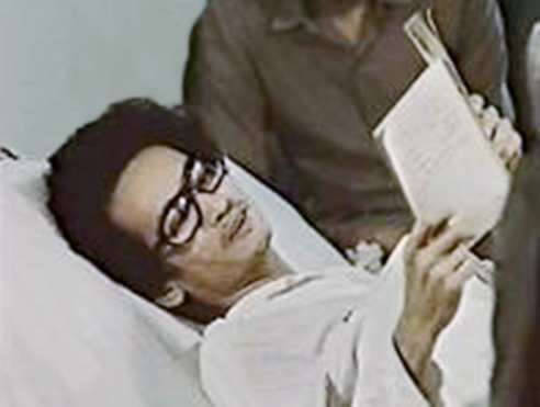 Đồng Xuân Thuyết reading a book in bed.